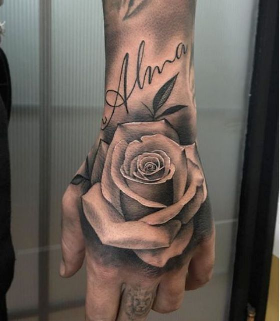 Tatouages de roses noires sur les mains grandes sur toute la main dans la partie supérieure avec le nom d'inscription Alma