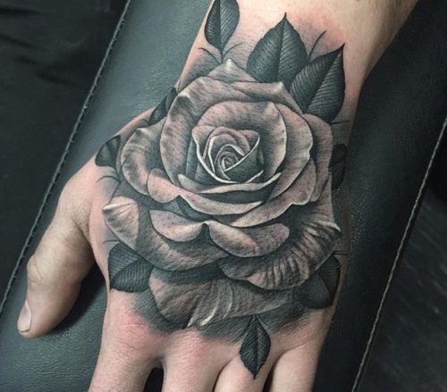 Tatuagens de rosas negras nas mãos muito grandes na mão