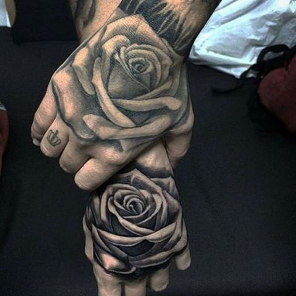 Tatouages de roses noires sur les mains pour les couples une main attrape l'autre