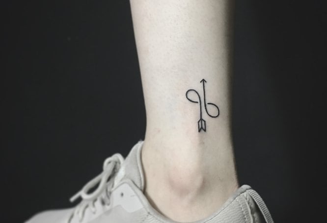Tatuajes de Simbolo Malin infinito mas flecha en pantorrilla
