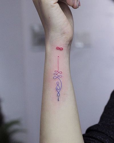 Unalome tattoos on the side of the wrist with infinity symbol in red and violet colors