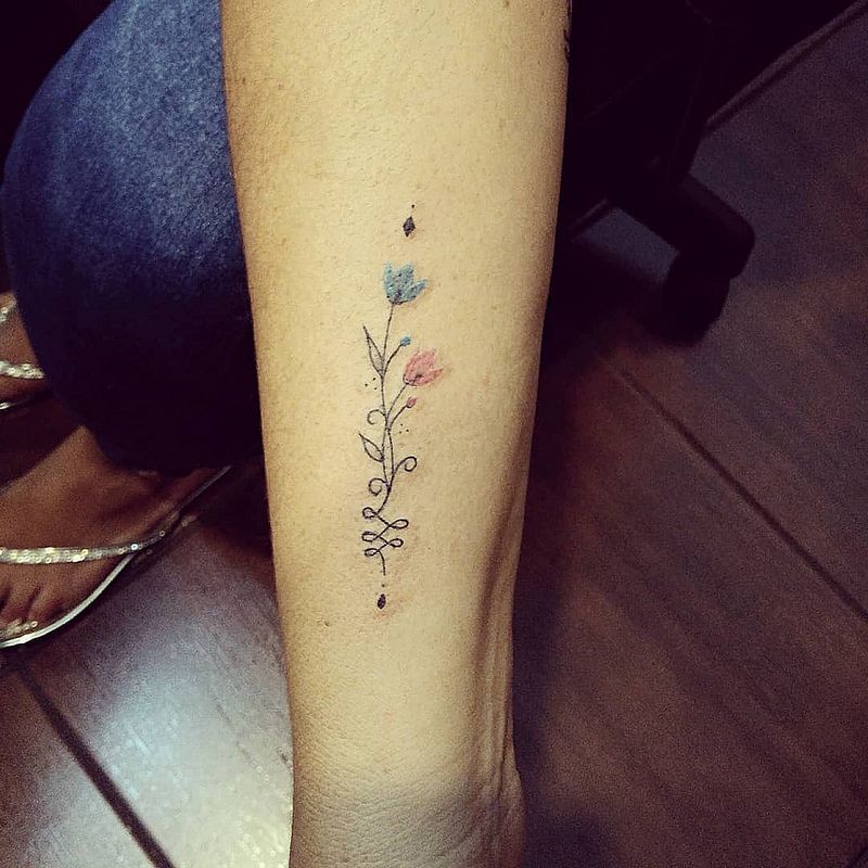 Tatouages Unalome avec deux petites fleurs bleu clair et rose