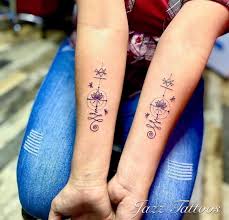 Unalome Tattoos auf beiden Unterarmen der Frau