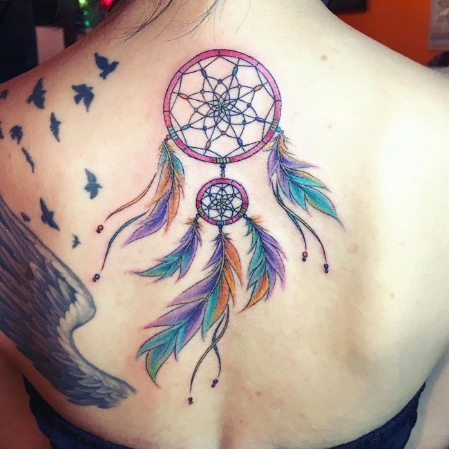 Dream catcher tattoos angel callers two circles on the back with reddish tones