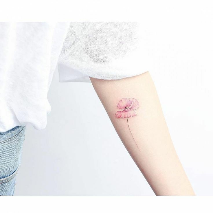 Tatuaggi di fiori rossi con fini petali di papavero sul braccio di una donna