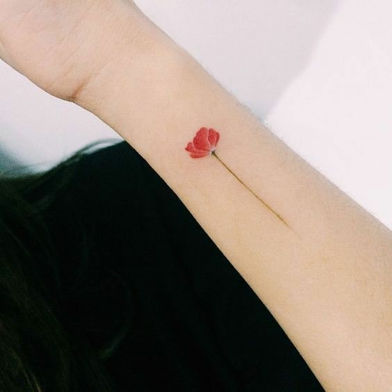 Rote Blumen-Tattoos mit feinen Mohnblütenblättern am weiblichen Handgelenk