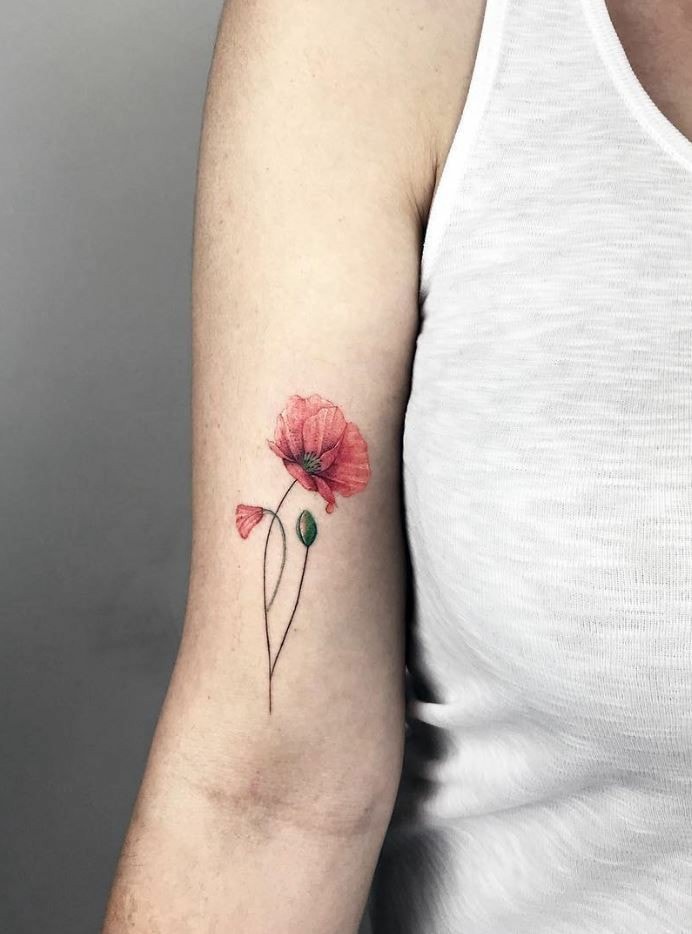 Small red flower tattoos with fine poppy petals on arm