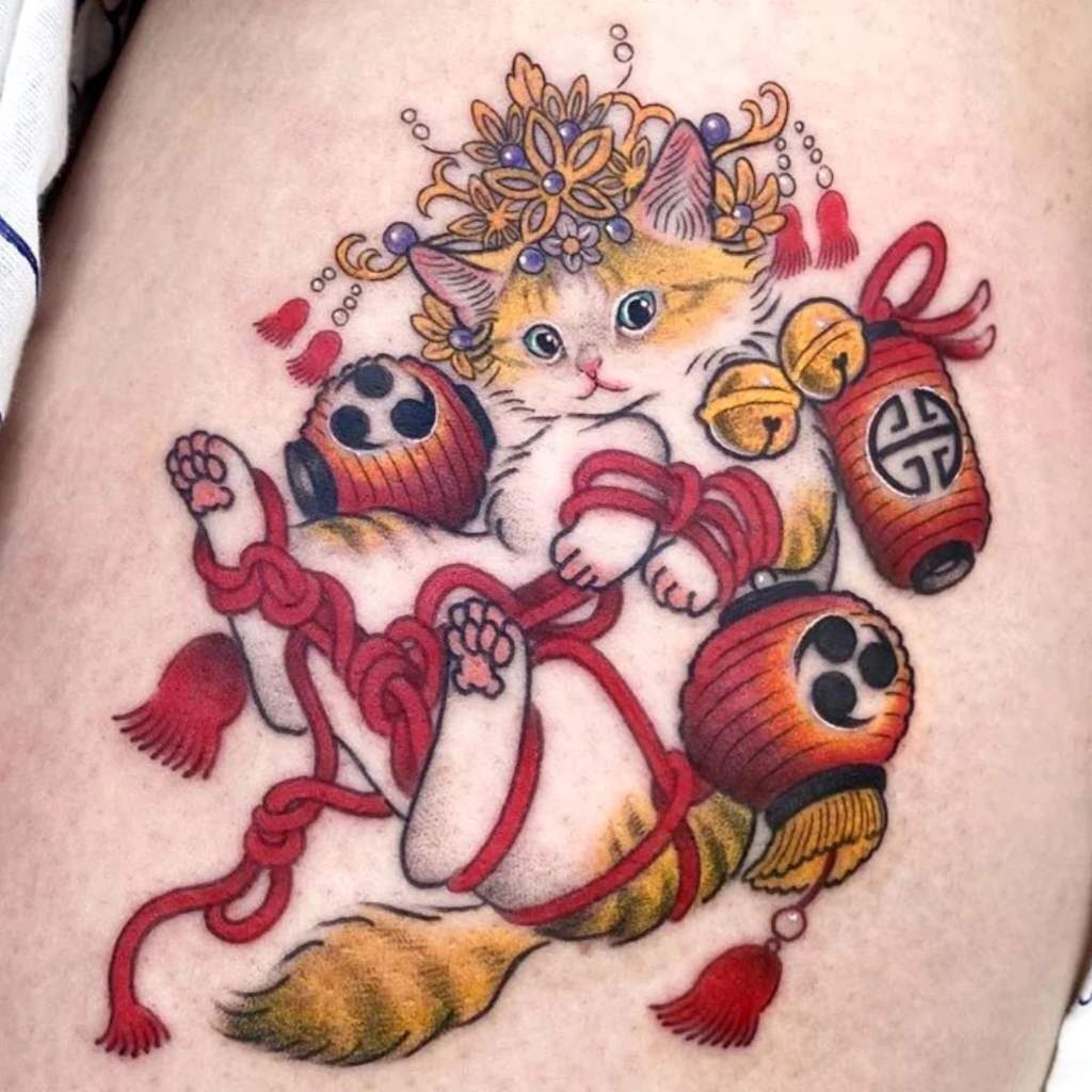 Tatuaggi di bellissimi gatti, gatto arancione aggrovigliato in una palla rossa con corona di fiori