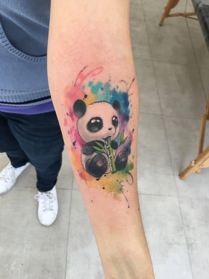 Panda bear tattoos in watercolor on forearm with bamboo cane