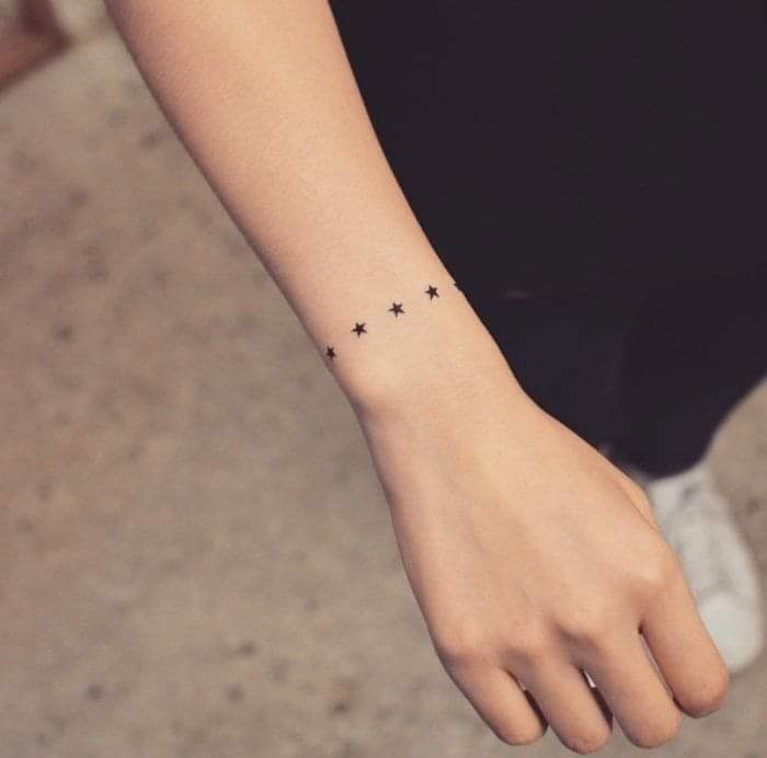Tatuaggi delicati per donne con piccole stelle tipo bracciale