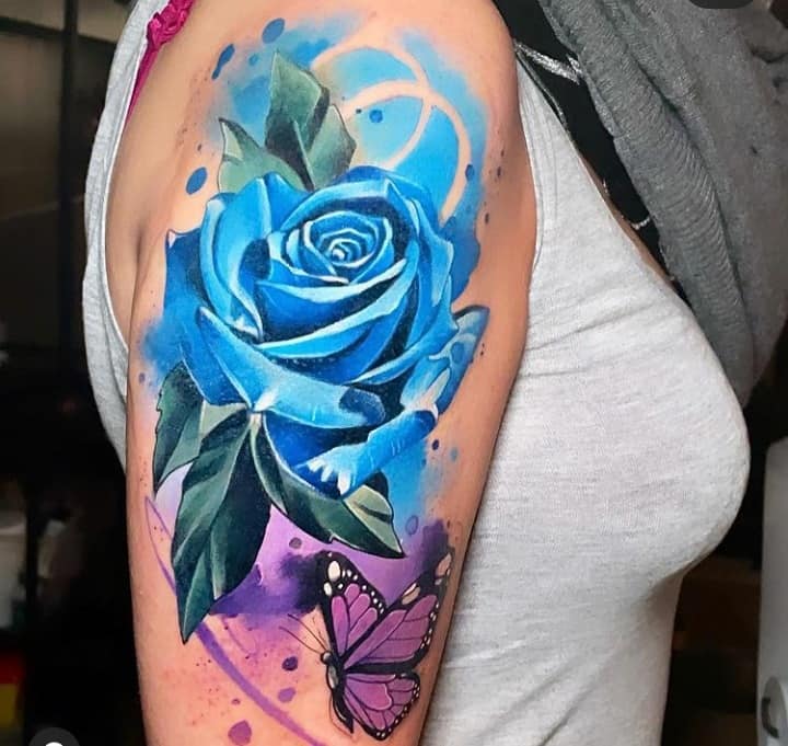 Tatuagens enormes em aquarela rosa azul celeste e borboleta roxa no braço
