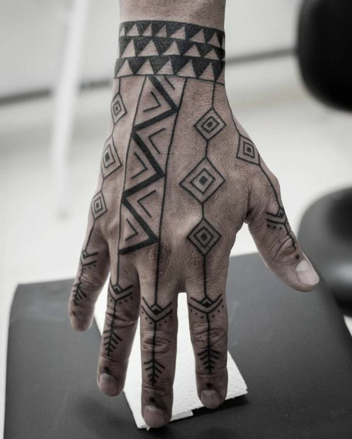Tätowierungen auf den Händen mit geometrischem Muster aus Zickzack und Rauten
