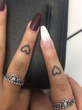 Tattoos on the fingers of the hand hearts on two fingers