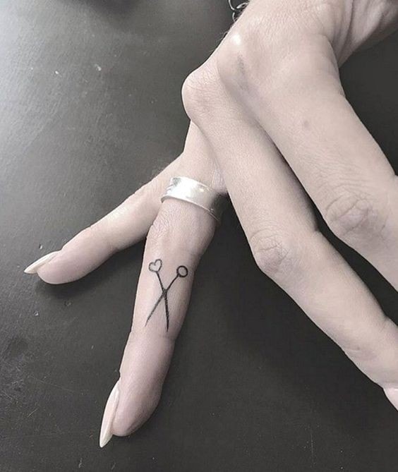 Tattoos on the fingers of the scissor hand