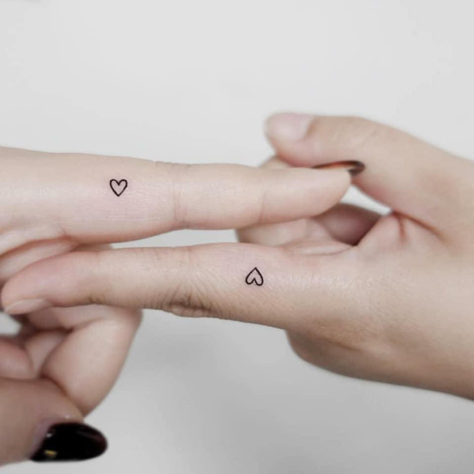 Tatuagens minimalistas para casais irmãs primas amigas dois corações em ambos os dedos indicadores