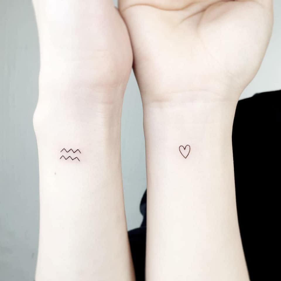 Tatuaggi minimalisti per coppie sorelle cugini amici simbolo dell'acqua e del cuore sui polsi