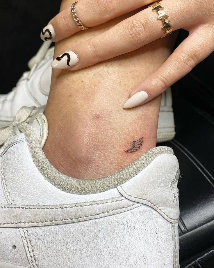 Tatuajes minimalistas super pequenos ala de agel en pantorrilla