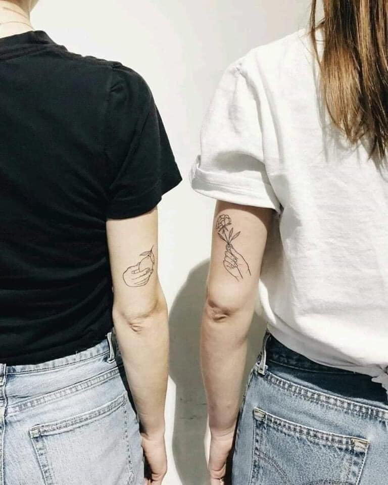Tatuagens para amigos mão e fruta e mão e rosa no braço