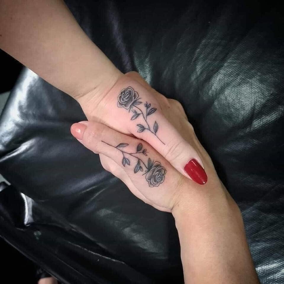 Tatuaggi per i migliori amici che tengono le mani sui pollici con una rosa nera