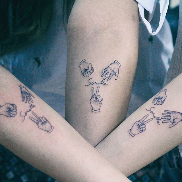 Tattoos für drei Freunde, Schwestern, Cousins, Hände, die Stein, Papier, Schere und das Wort Sorelle-Schwestern auf Italienisch darstellen