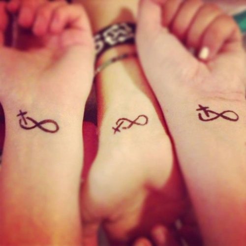 Tatuaggi per tre amici, sorelle, cugini, infinito con una croce su ciascun polso