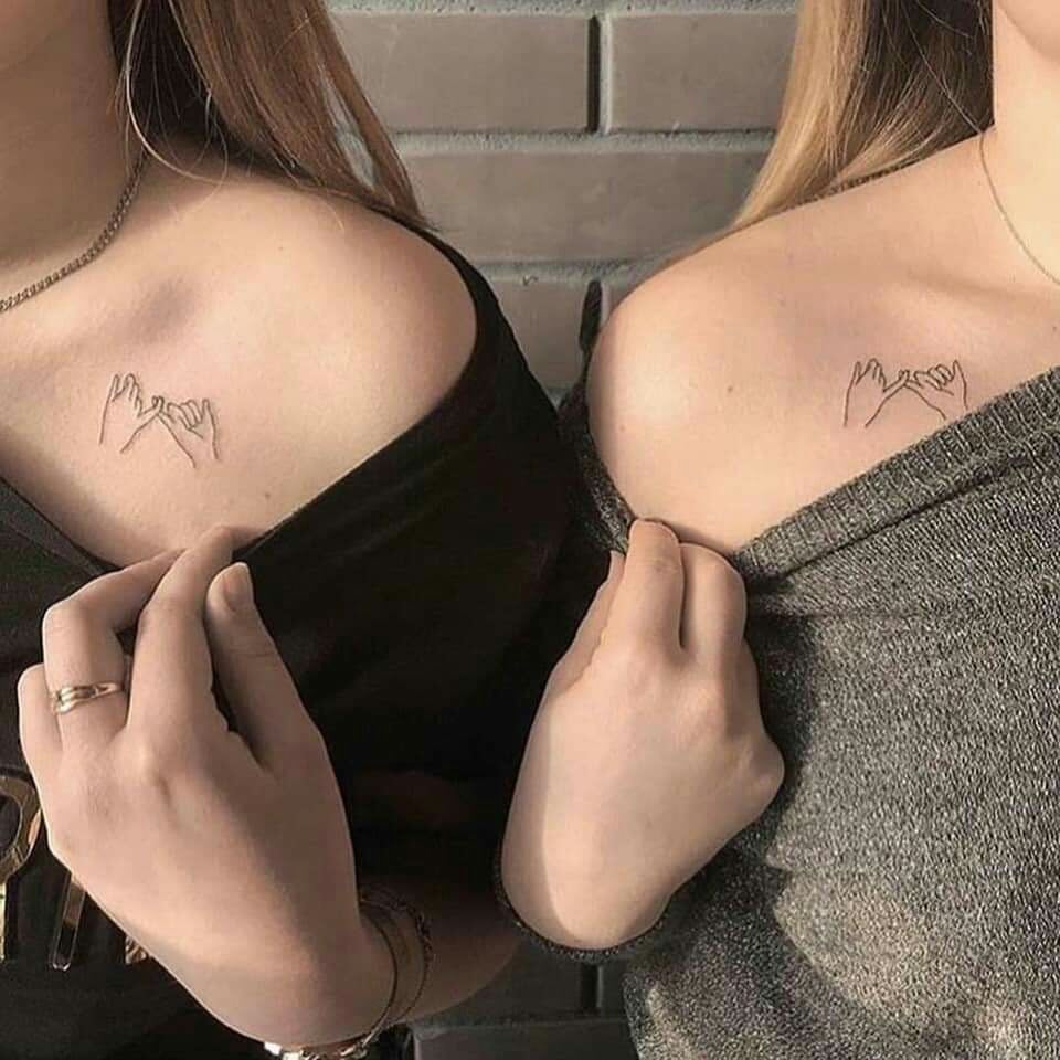 Tatuajes para mujeres dos amigas con dos tatuajes de dedos cruzados en hombro