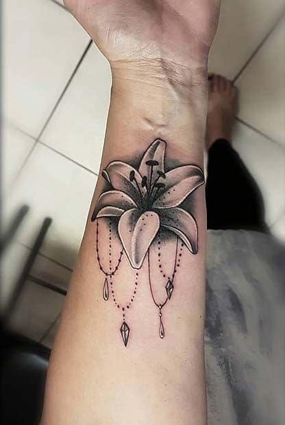 Tatuajes para mujeres flor de loto y cadenitas con pendientes
