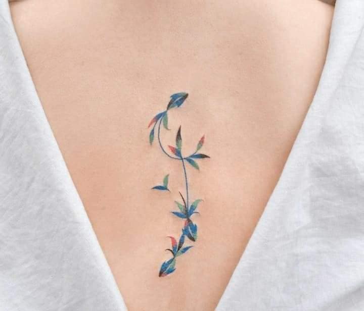 Really beautiful detail tattoos on the back of twigs with blue and black leaves