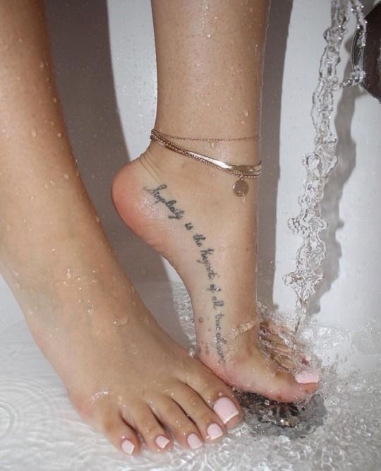 Delicate tattoo on the foot area of a woman inscription