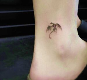 Petit tatouage de dragon sur la cheville femme sens