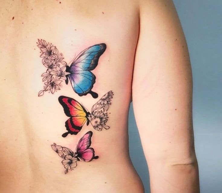 Tattoo mit 3 farbigen Schmetterlingen auf dem Rücken