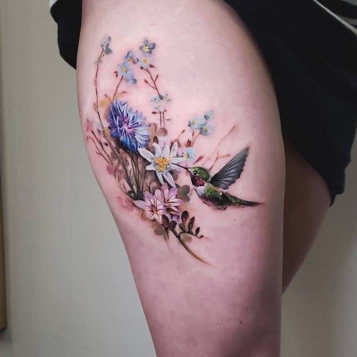 tatuaggio colibrì sulla coscia di una donna colorata 1