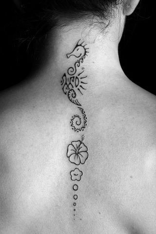 tatuagem nas costas mulher hipocampo e flores na coluna