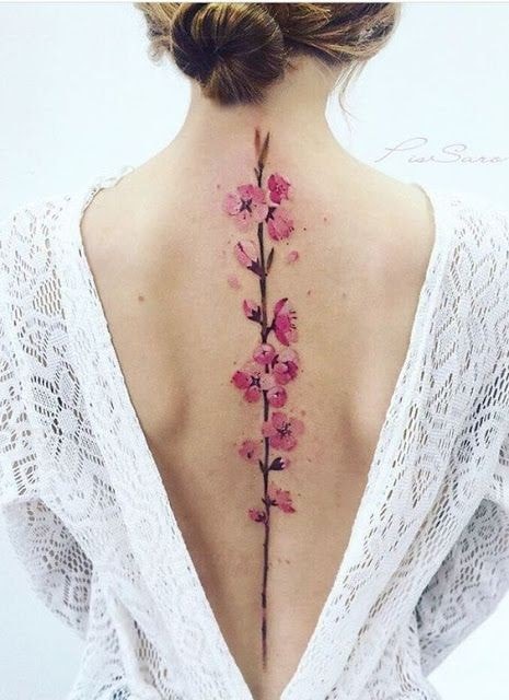 Tatouage femme dos complet tige fleur sur colonne vertébrale