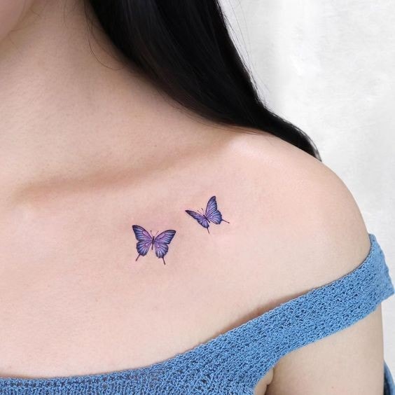 Kleines blaues Schmetterlings-Tattoo auf der Schulter der Frau 3