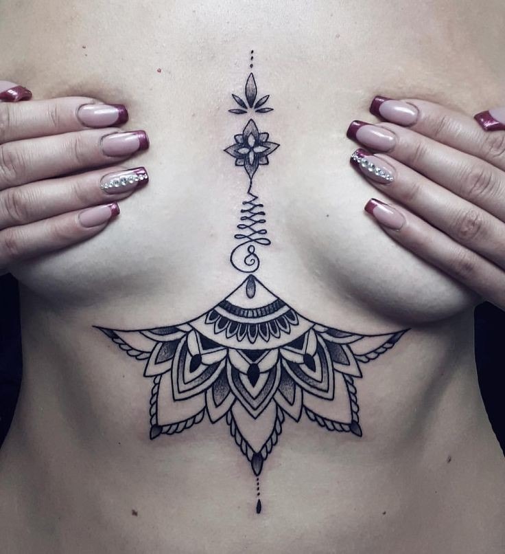 tatuaje pecho mujer mandala y llamador de angeles en medio de los senos