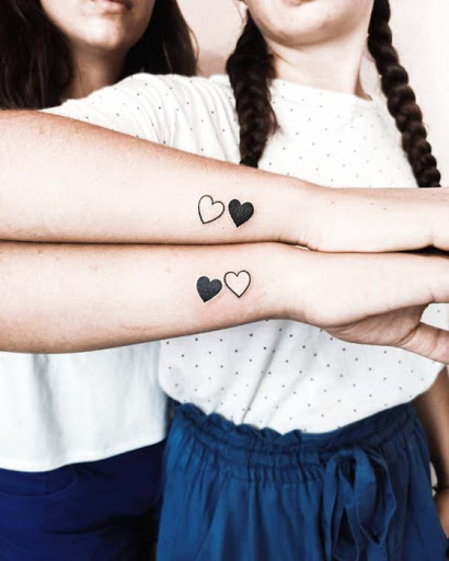 tatuaggi per amiche sorelle cugine cuori bianchi e neri sul polso